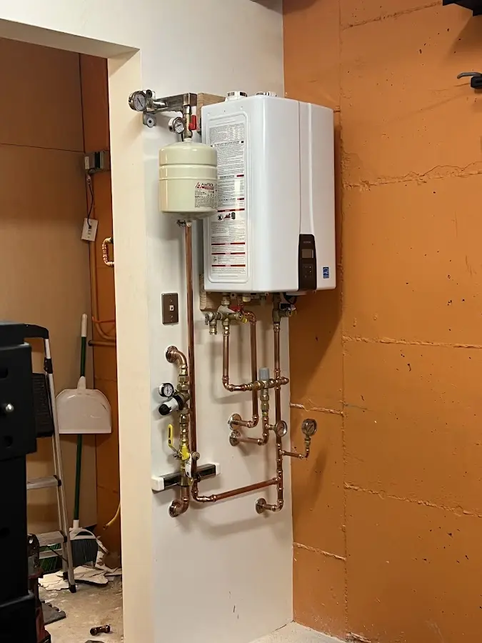 Plumbing technician inspecting water heater connections in Granite Quarry